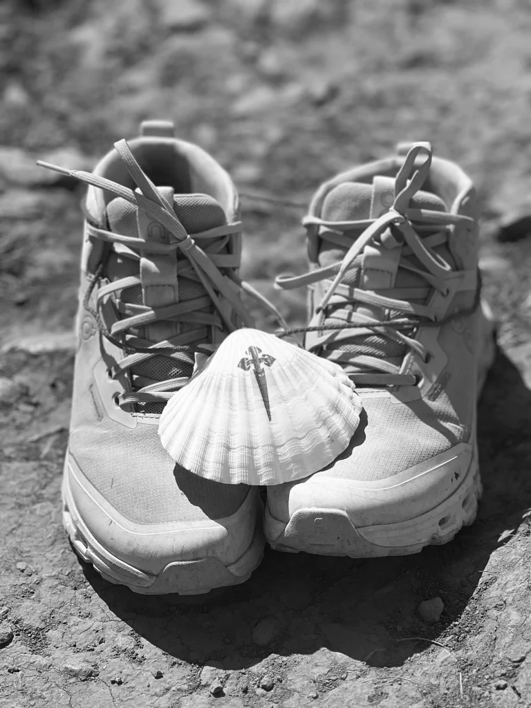 elisabethamann.com Das Cover des E-Books. Eine Muschel balanciert auf einem Paar Schuhe, mit denen der Jakobsweg beschritten wurde. Eine inspirierende Reise.